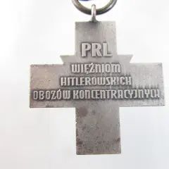 Srebrny krzyż z napisem "PRL WIĘŹNIOM HITLEROWSKICH OBOZÓW KONCENTRACYJNYCH".