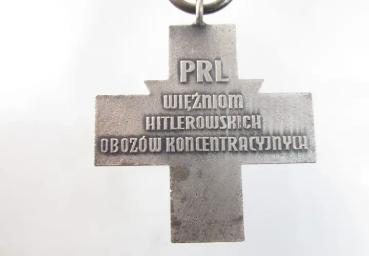 Srebrny krzyż z napisem "PRL WIĘŹNIOM HITLEROWSKICH OBOZÓW KONCENTRACYJNYCH".