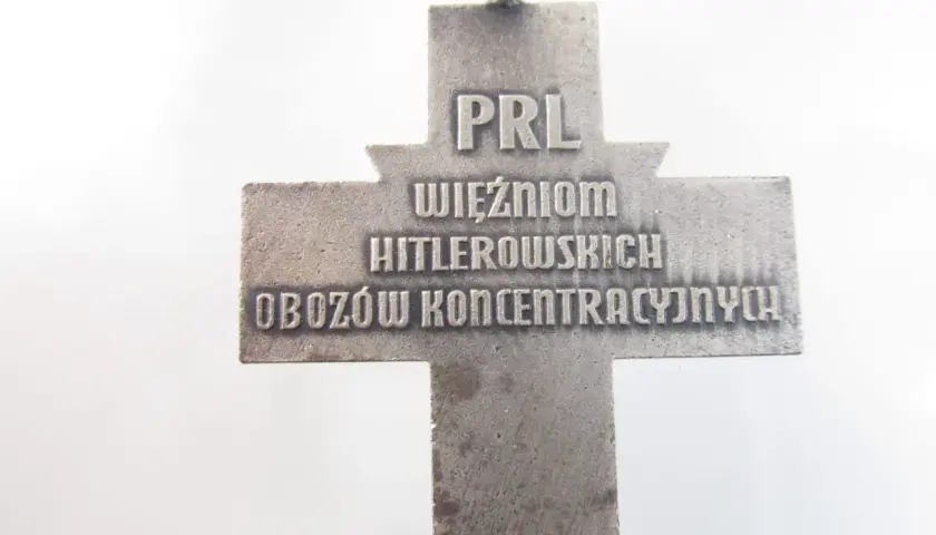 Srebrny krzyż z napisem "PRL WIĘŹNIOM HITLEROWSKICH OBOZÓW KONCENTRACYJNYCH".