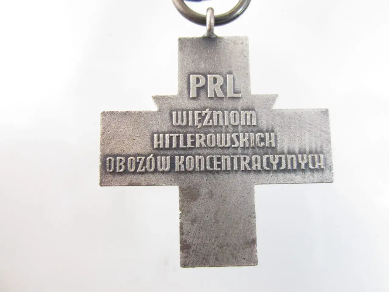 Srebrny krzyż z napisem "PRL WIĘŹNIOM HITLEROWSKICH OBOZÓW KONCENTRACYJNYCH".